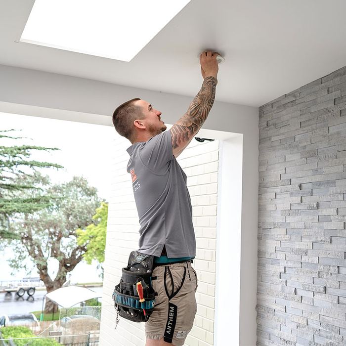 Electrician working on a ceiling light