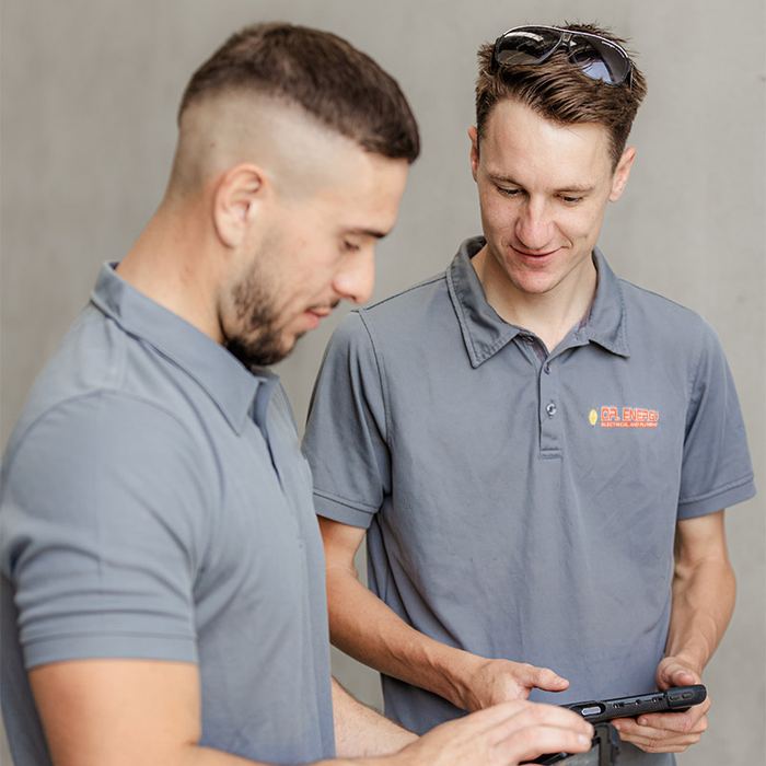 Two electricians reviewing a job